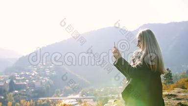 少女拍照从<strong>山顶</strong>移动电话景观城市景观，女游客<strong>站在</strong>悬崖上享受